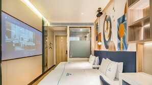 Una habitación de hotel con una cama grande, un escritorio y una pantalla de televisión mostrando la distribución de la habitación.