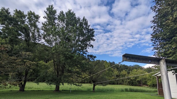Un'area verdeggiante con alberi e una struttura metallica.