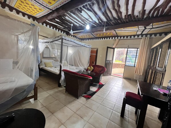 Quarto com uma cama, uma cadeira, uma mesa e um ventilador de teto.