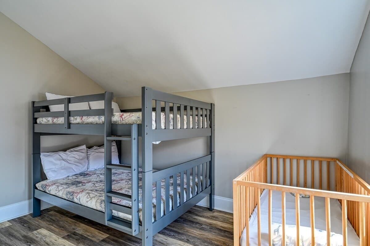 A bunk bed with a lower bunk and a wooden crib.