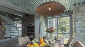 A dining area with a table set for breakfast, a fruit bowl, and a vase with flowers. - Sala Comacina Villas by Rent all Como (Sala Comacina)