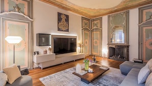A spacious living room with a large flat-screen TV, a fireplace, and a comfortable seating area. - Rovelli 41 by Rent all Como (Como)