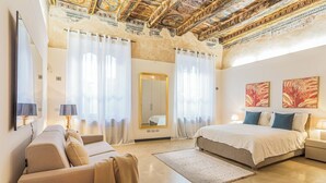 A spacious bedroom with a large bed, a sofa, a mirror, and a chandelier. - Rovelli 41 by Rent all Como (Como)
