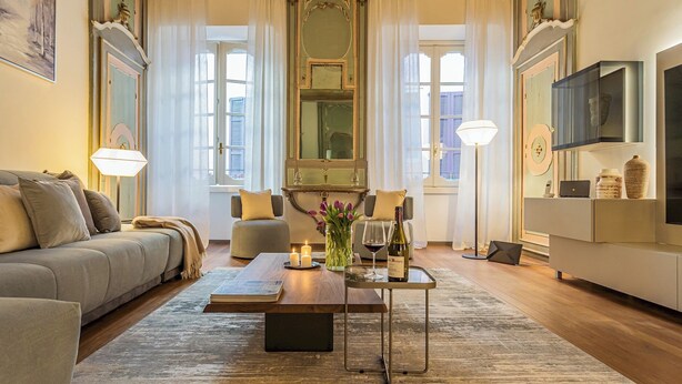 A modern living room with a sofa, a coffee table, and a TV on a cabinet. - Rovelli 41 by Rent all Como (Como)