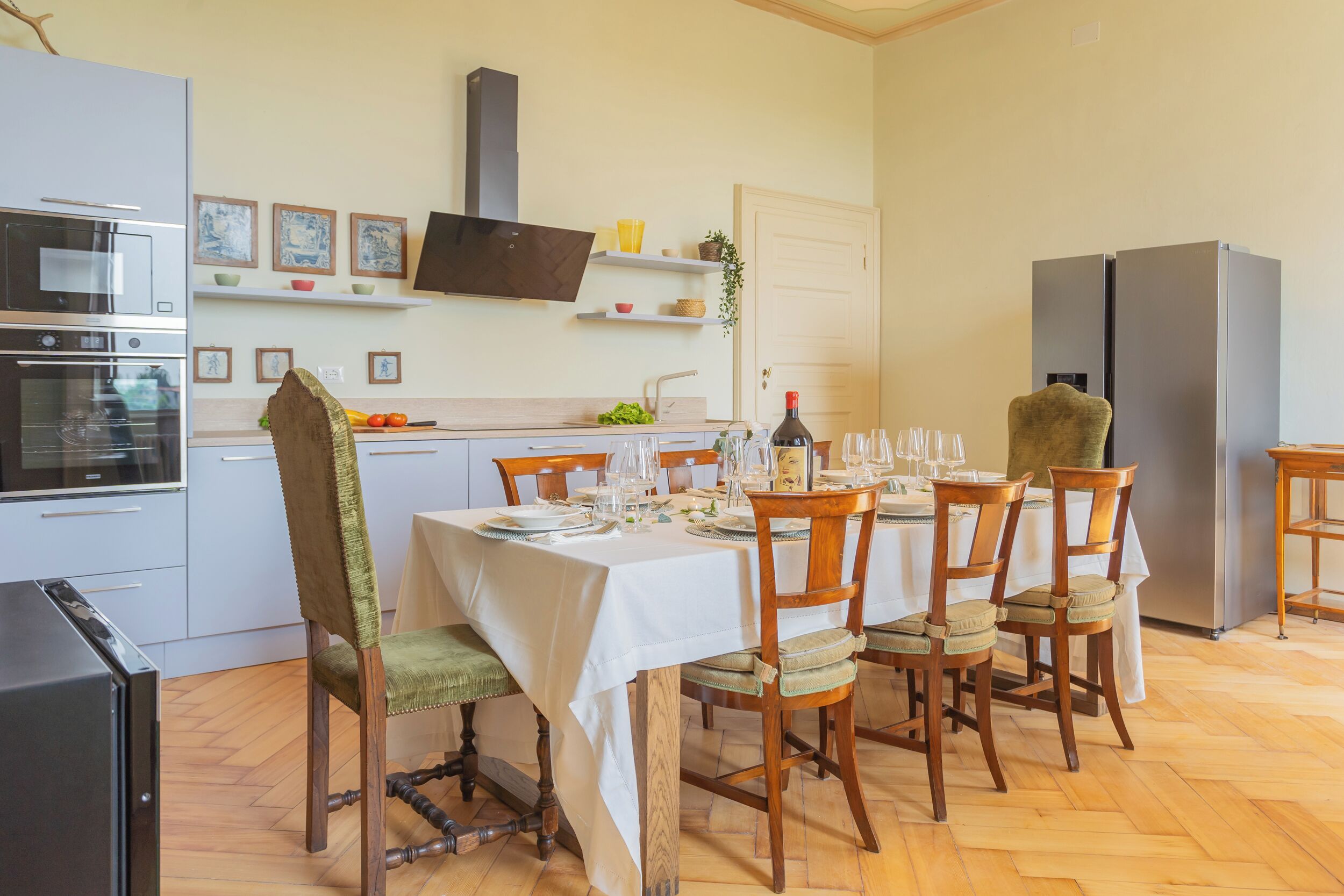 Uma cozinha moderna com uma mesa de jantar posta para quatro pessoas, equipada com micro-ondas, forno e frigorífico.