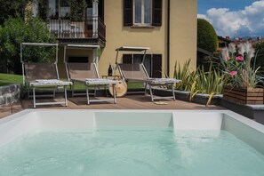 A pool area with lounge chairs and a hot tub. - Villa Ida by Rent all Como (Tremezzina)