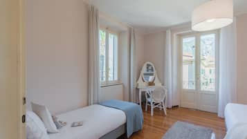 Une chambre à coucher avec un lit, un bureau avec une chaise et une fenêtre avec des rideaux.