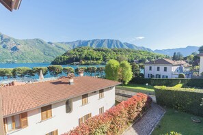 Villa, jossa on tiilikatto, kivipolulla varustettu puutarha sekä näkymä järvelle ja vuorille.