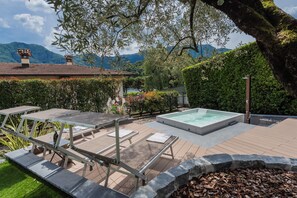 A rooftop pool area with lounge chairs and a hot tub, surrounded by greenery and mountains in the background. - Villa Ida by Rent all Como (Tremezzina)