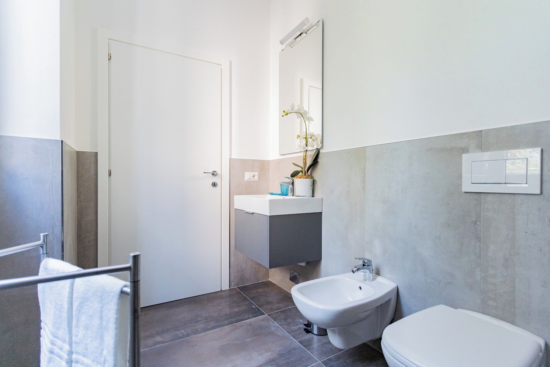 Un baño moderno con inodoro, bidé y lavamanos.