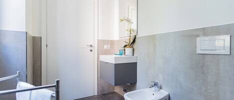 Un baño moderno con inodoro, bidé y lavamanos.