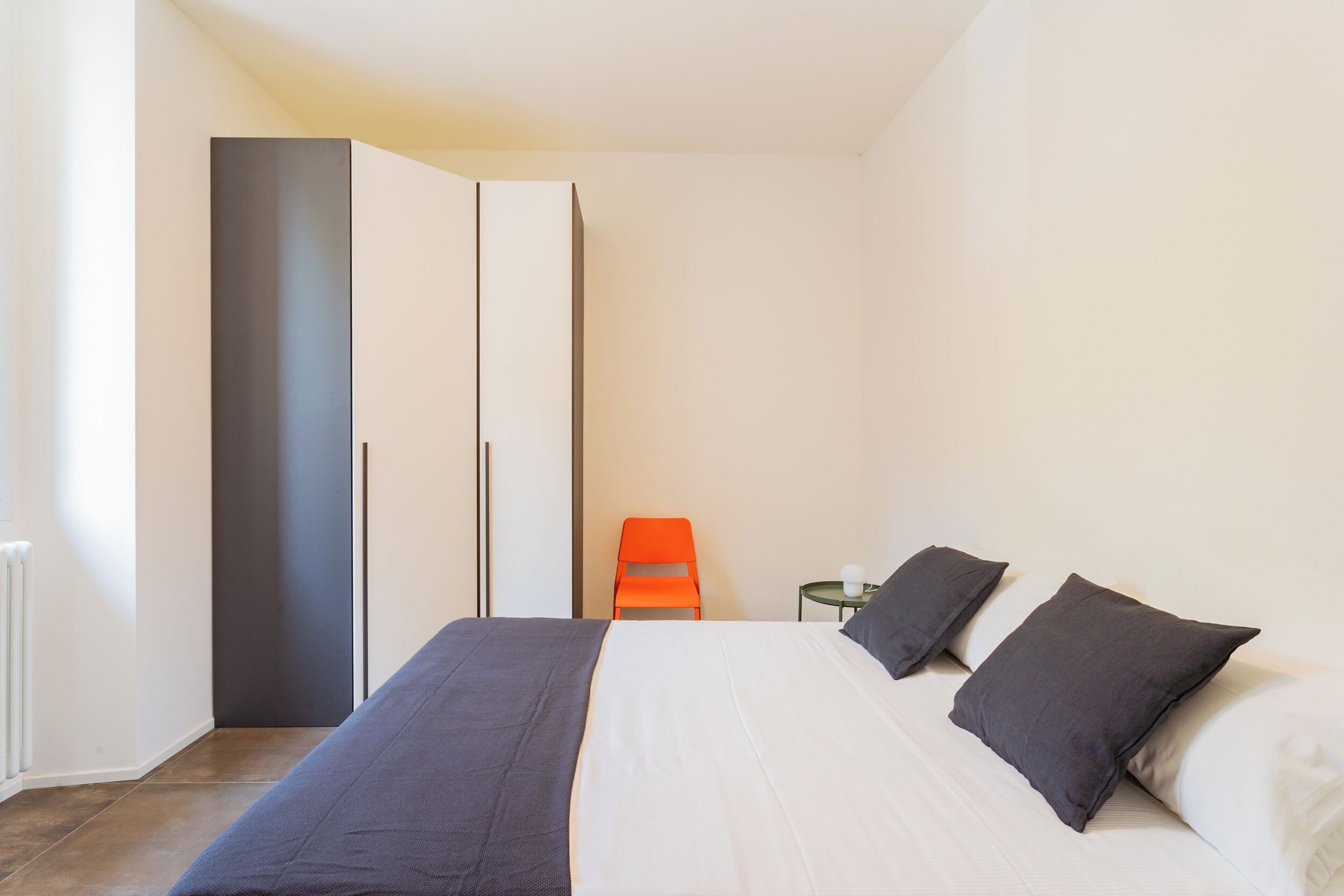 Una camera da letto con un letto, un armadio e una sedia.