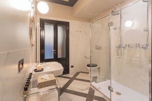 Un baño moderno con ducha de vidrio, bañera y retrete.