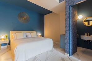 Un dormitorio moderno con una cama grande, lámparas de noche y un elemento decorativo en la pared.