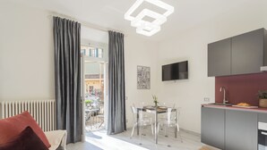 A modern apartment with a dining area, kitchen, and a view of the outside balcony. - Cernobbio Dream Suites by Rent all Como (Cernobbio)