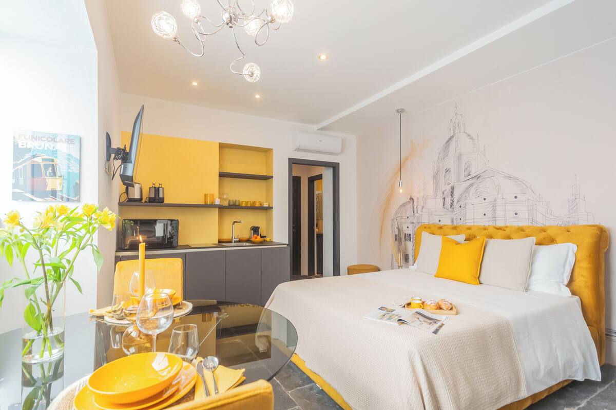 Una habitación de hotel moderna con cama, comedor y cocina.