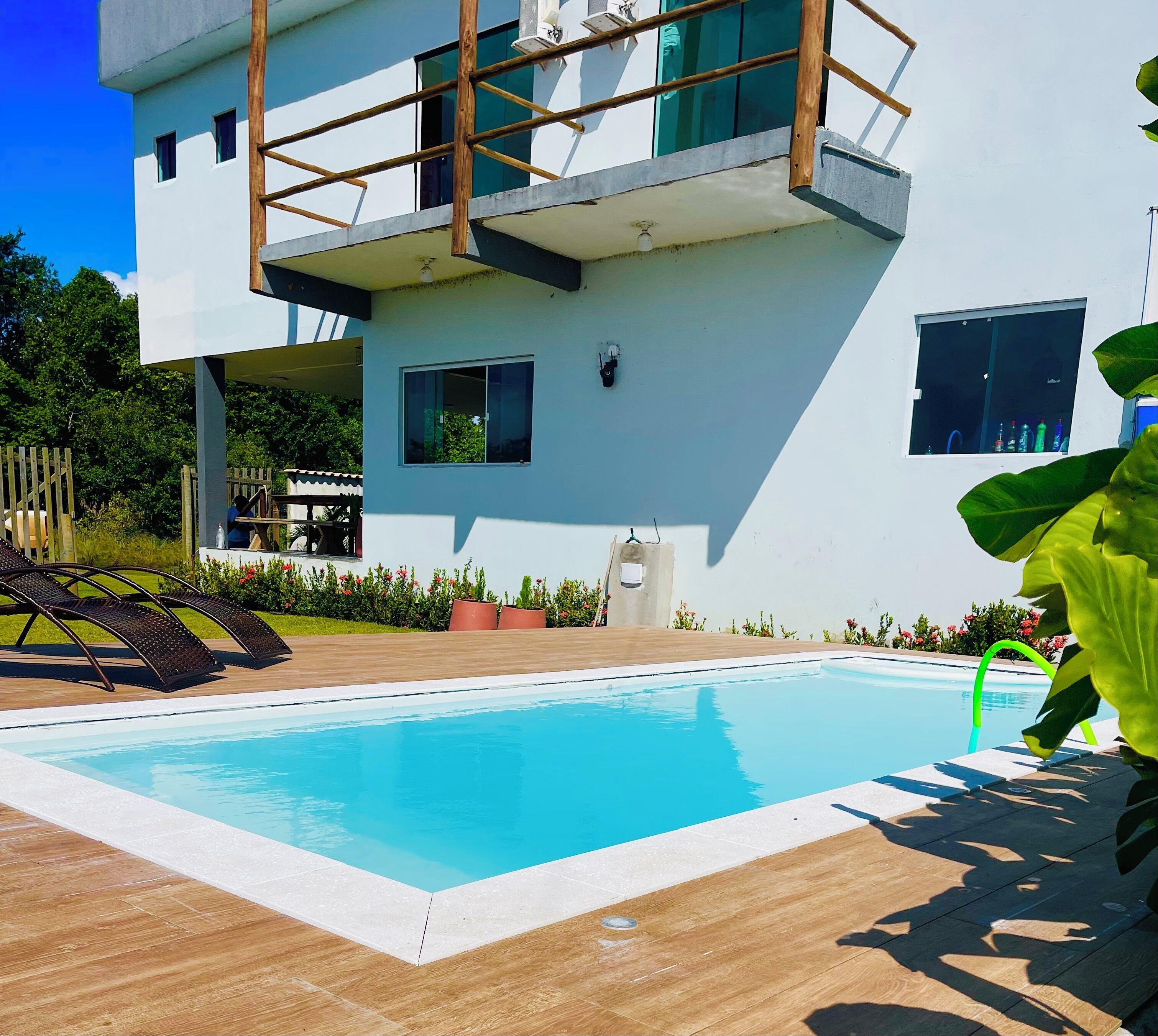 Un bâtiment moderne doté d’une piscine, d’un espace extérieur aménagé et d’une terrasse en bois.