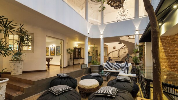 Un vaste espace intérieur doté d’un haut plafond, de sièges rembourrés de couleur noire et d’un escalier menant à un niveau supérieur.