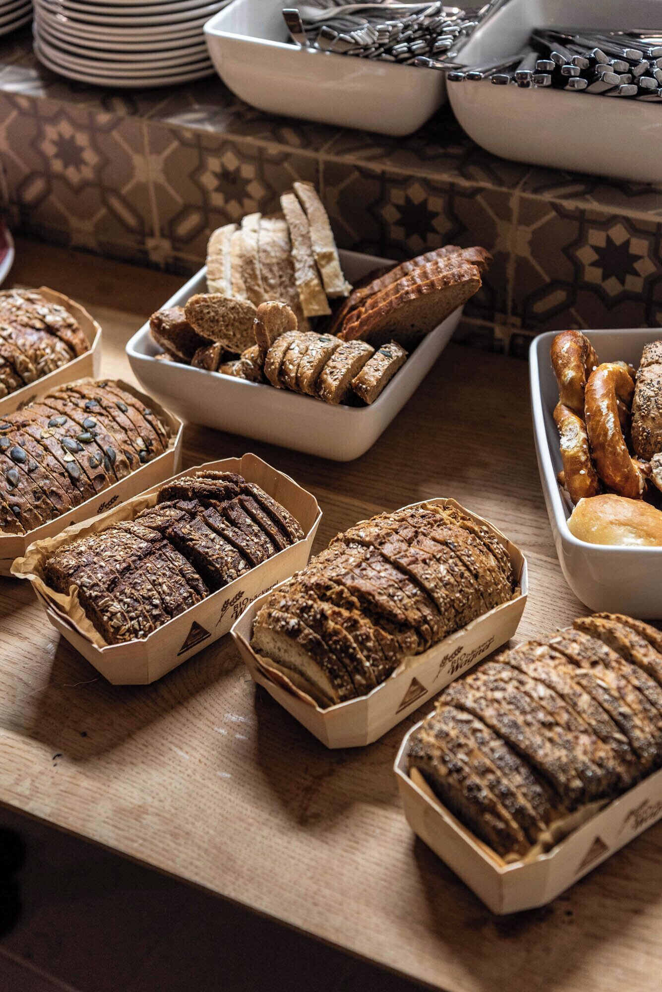 A variety of breads and pastries on a wooden table.