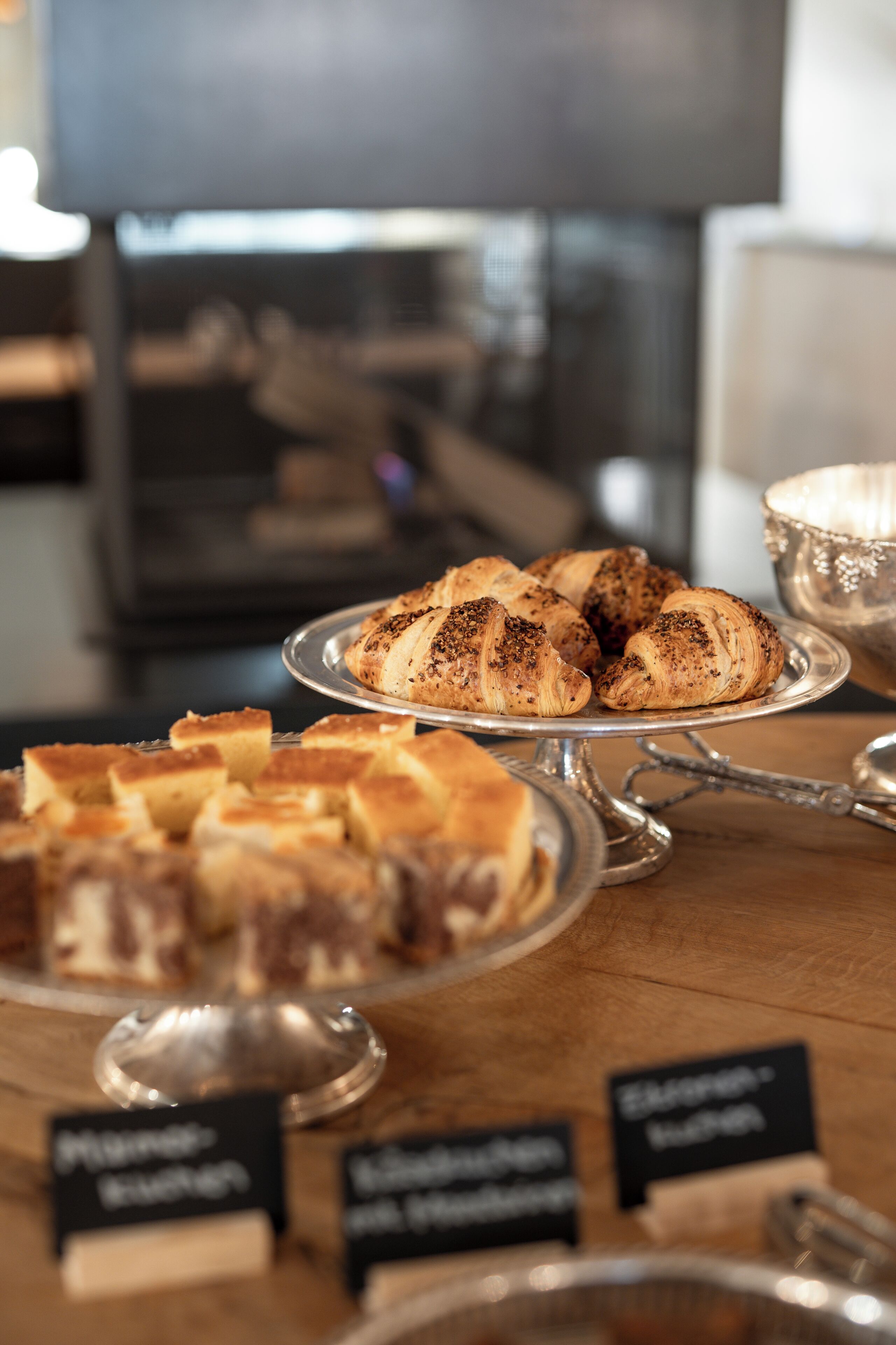 Une vitrine de boulangerie présentant des croissants et d’autres viennoiseries, avec des étiquettes indiquant les différents types.