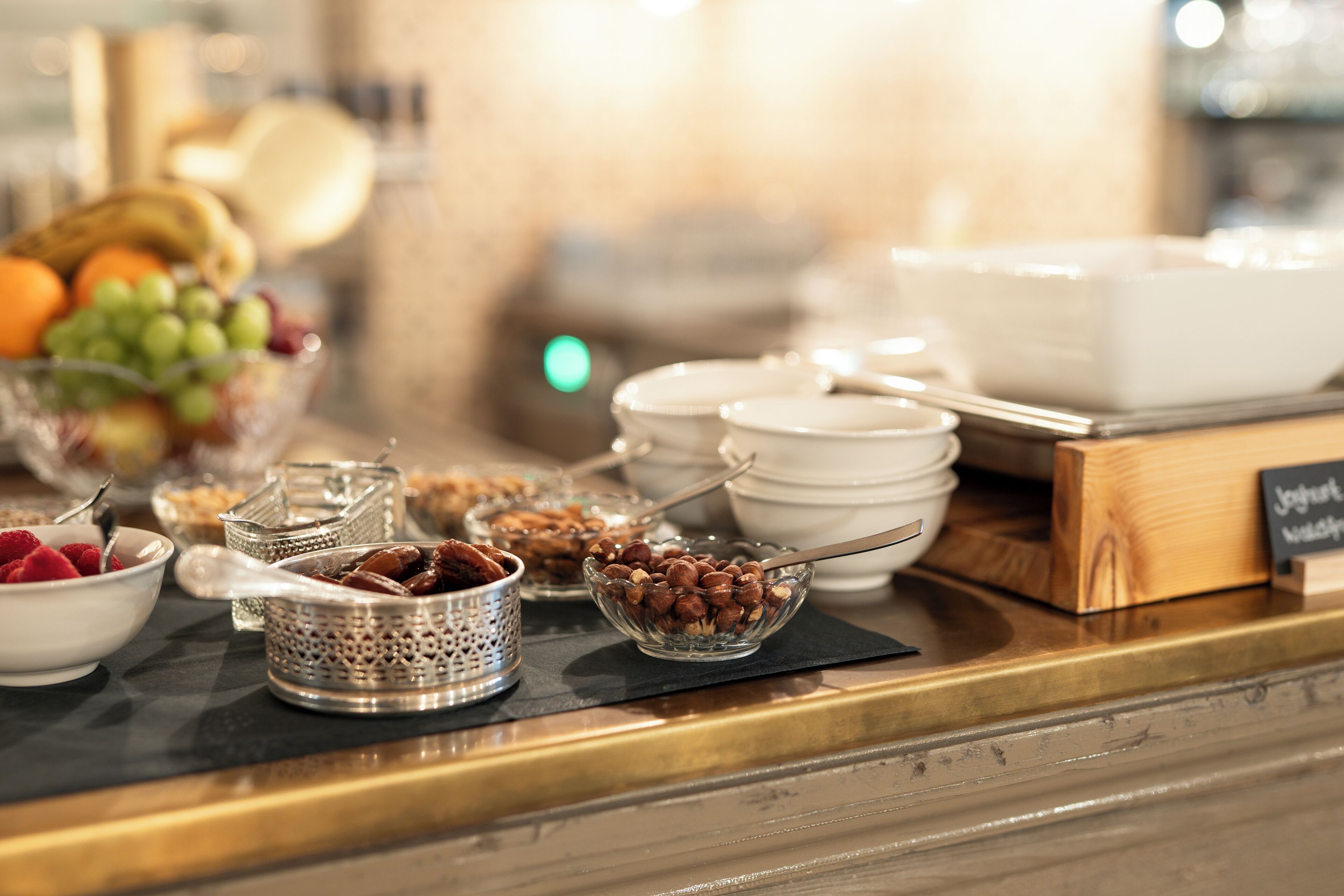 A breakfast buffet with various food items and serving utensils.
