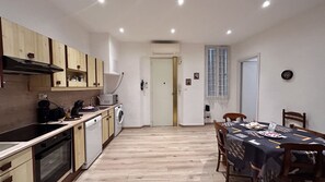 Una cocina compacta con armarios de madera, lavavajillas y lavadora.