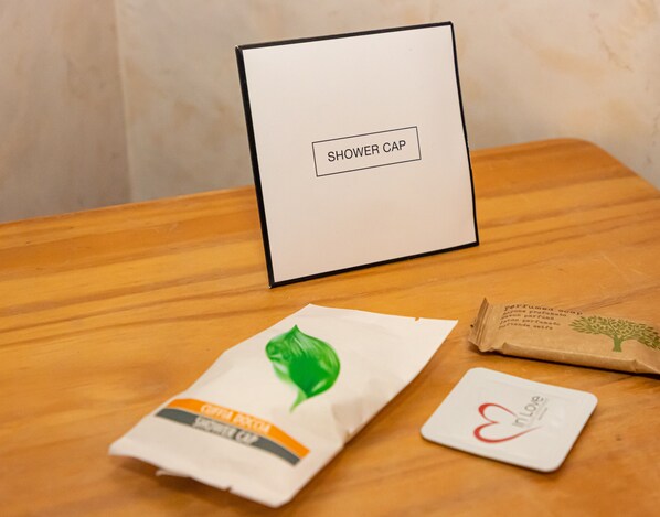 A wooden table with a white box labeled "SHOWER CAP" and two packages, one with a green leaf design and another with text.