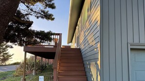A wooden staircase leading to a porch with a mailbox and a 'Sea-N-Nite' sign.