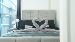 A hotel room with a bed, a headboard, a nightstand, and a window.