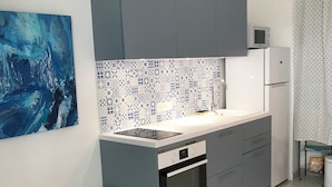 Een moderne keuken met grijze kastjes, een wit aanrechtblad en een decoratieve spatwand.