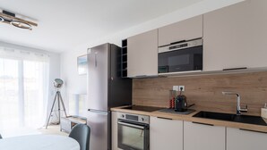 Una cocina moderna con horno integrado, microondas y pileta.