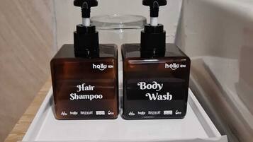 Two bottles of hair and body wash on a white tray with a clear plastic bag underneath.