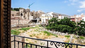 Vista de ruinas antiguas con edificios modernos al fondo.