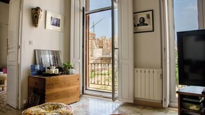 Un salón amplio con un gran ventanal, un armario de madera y un televisor.