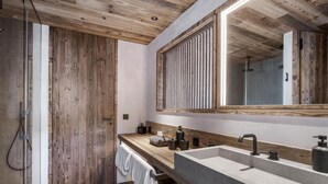 A modern bathroom with a wooden ceiling, a large mirror, and a built-in sink. - Spacious chalet with Nordic bath and steam room in Saint-Martin-de-Belleville (Saint-Martin-de-Belleville)