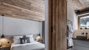 A modern bedroom with a large bed, bedside tables, and a wooden ceiling. - Spacious chalet with Nordic bath and steam room in Saint-Martin-de-Belleville (Saint-Martin-de-Belleville)