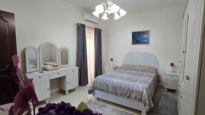 Quarto com cama, cómoda com espelhos, mesa de cabeceira e ar condicionado fixado na parede.