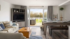 Een moderne woonkamer met een bank, tv en eethoek.