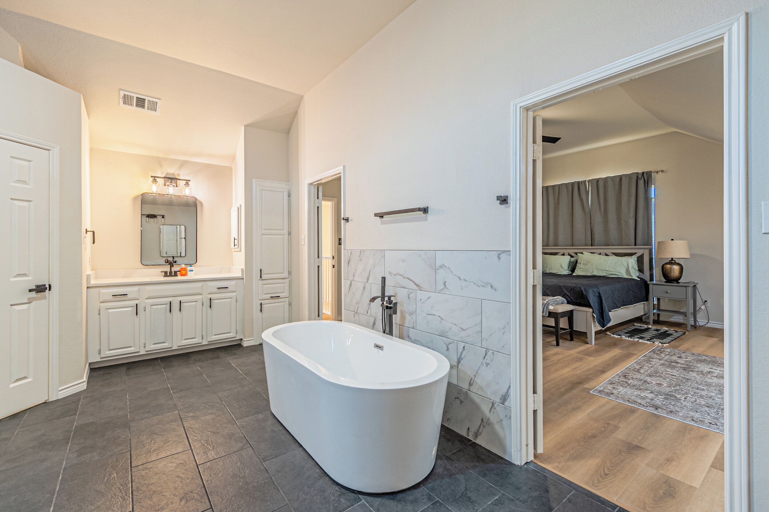 Une salle de bain moderne avec une baignoire sur pieds, un meuble-lavabo avec un miroir et un espace douche.
