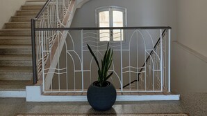 A staircase with a white railing and a potted plant at the bottom. - La Piattaforma, your home with a private sea view (Santa Cesarea Terme)