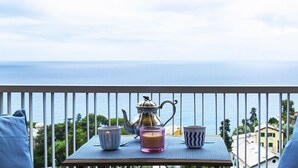 A balcony with a table set for tea, a candle, and a mug, overlooking a coastal view. - Casa Bianca a Bogliasco by Wonderful Italy (Bogliasco)