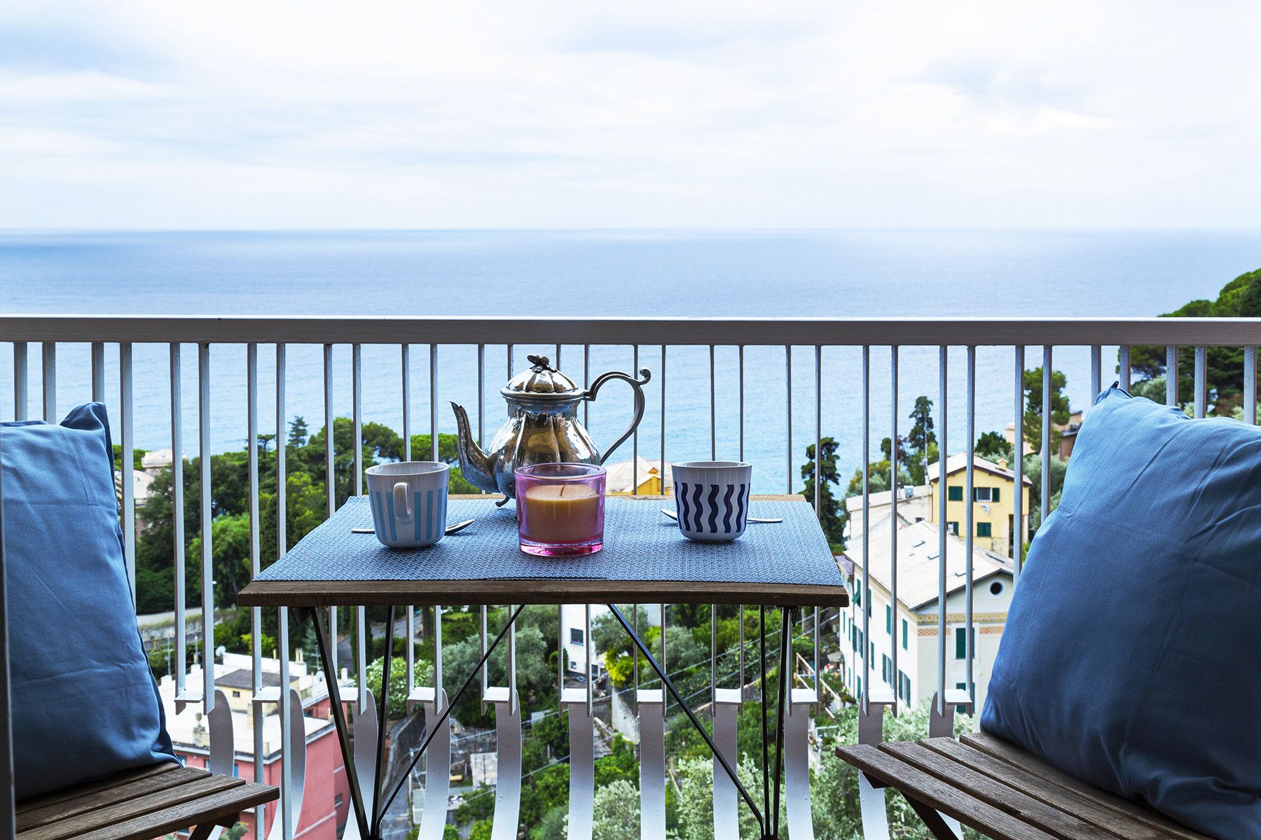 Ein Balkon mit Tisch für zwei Personen, mit Blick auf die Küste.