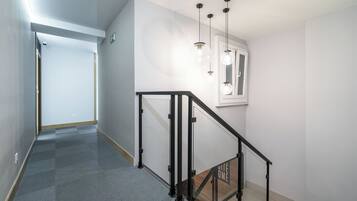 A modern interior with a staircase, a hallway, and a window with a view.