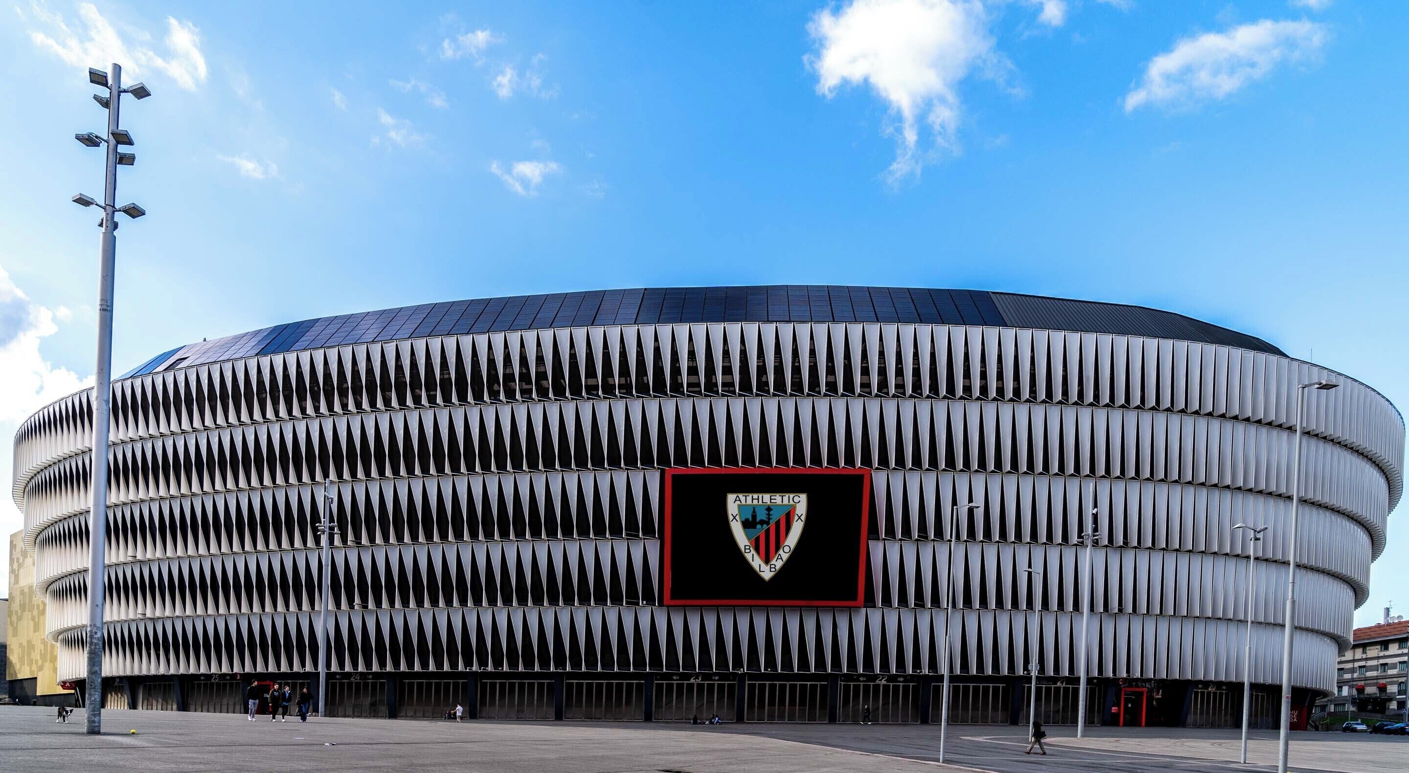 Een stadion met een opvallende buitenkant, gekenmerkt door een reeks driehoekige panelen.