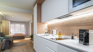 A modern kitchen with white cabinetry, a built-in oven, and a coffee machine. - Limehome Bilbao Tristan de Leguizamon (Bilbao)
