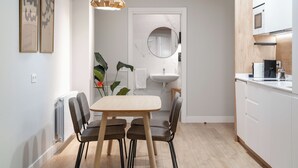 A modern kitchen with white cabinets, a wooden countertop, and a built-in oven. - Limehome Bilbao Tristan de Leguizamon (Bilbao)