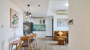 A modern living room with a dining area, a kitchen in the background, and a brown leather sofa. - Masteri view Landmark 81, downtown city 5mins-metro (Hồ Chí Minh)