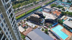 A high-rise building with multiple balconies, a swimming pool, and a covered outdoor area with a curved roof. - Masteri view Landmark 81, downtown city 5mins-metro (Hồ Chí Minh)