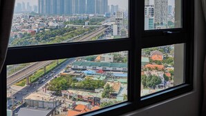 A cityscape through a window with a view of high-rise buildings and a highway. - Masteri view Landmark 81, downtown city 5mins-metro (Hồ Chí Minh)
