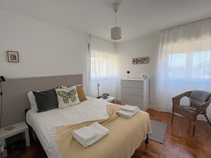 Un dormitorio con una cama, un aparador, una silla y una mesita de noche.